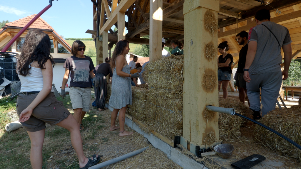 Participants work on a straw bale wall using natural building techniques.