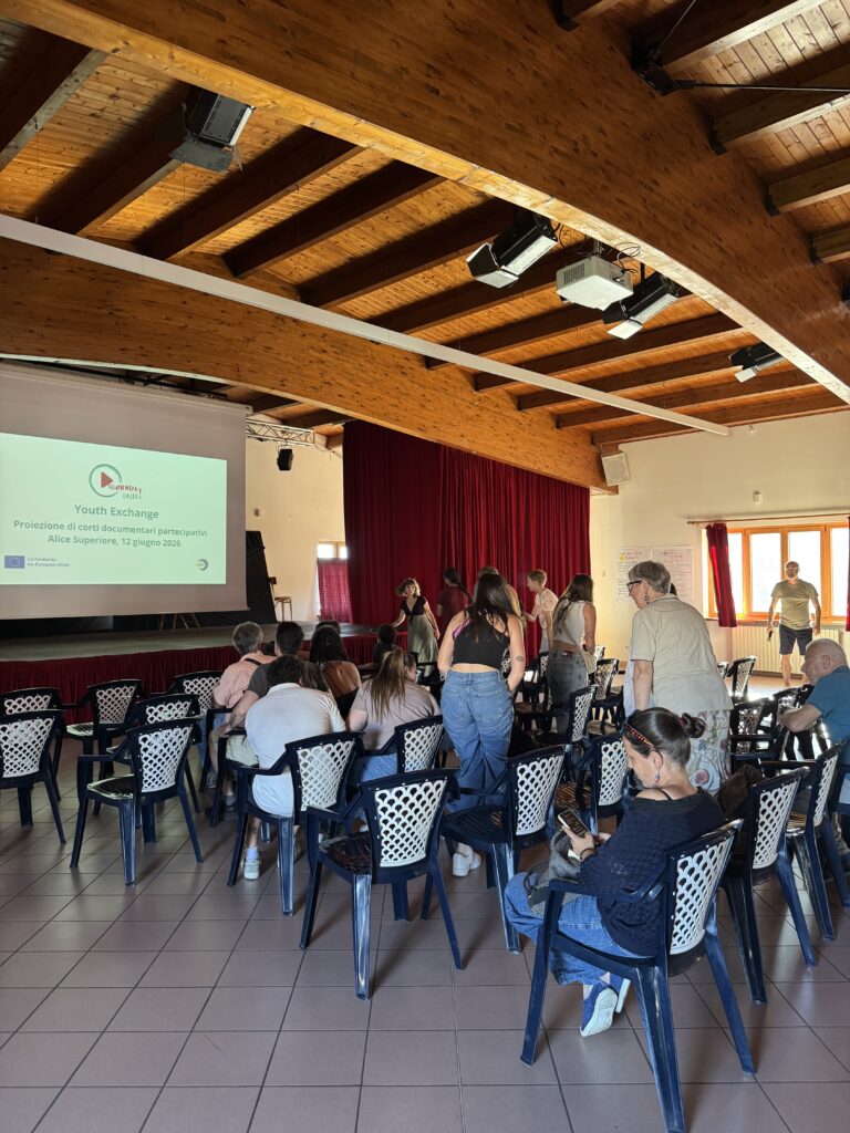 Young people and community members gather in a hall for a public screening of the documentaries created during the Documentary Circles Rural Youth Exchange.
